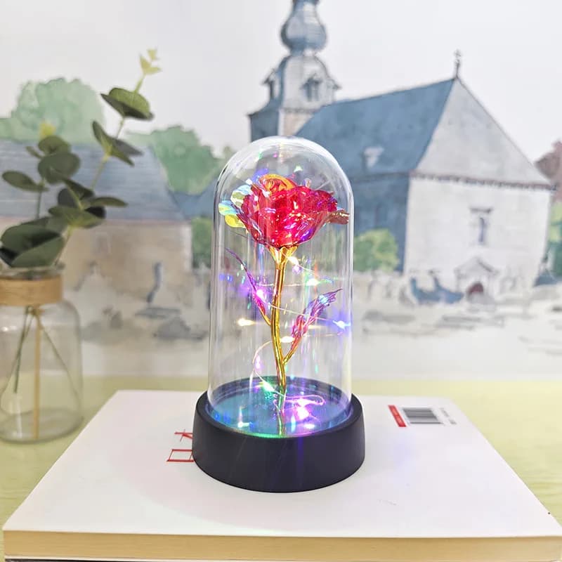 Dôme en verre de Rose rouge sur Base en bois, lumière d'ambiance chaude, pétales de Rose rouge en so